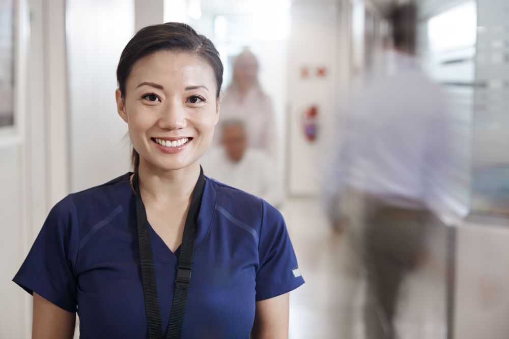 A smiling nurse in a hospital hallway