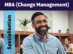 A man in a blue shirt sitting in an office with an MBA Change Management banner.