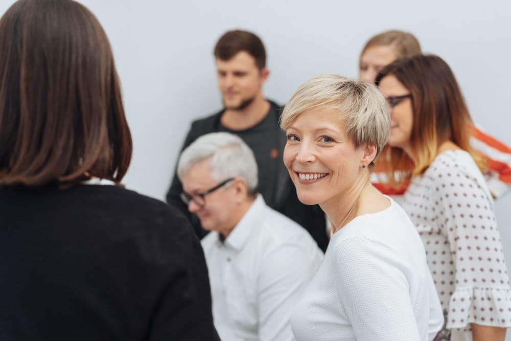 A public health professional smiles in a group of people. 