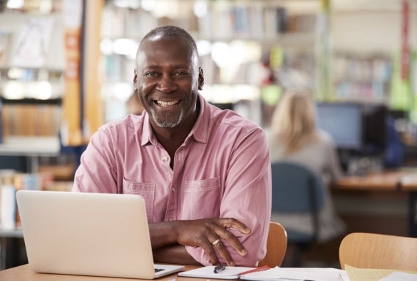 A smiling financial adviser working on their laptop.