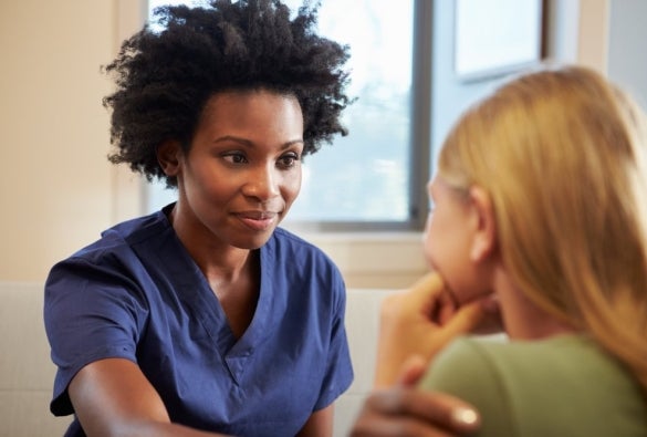 A mental health nurse comforting and helping a patient.