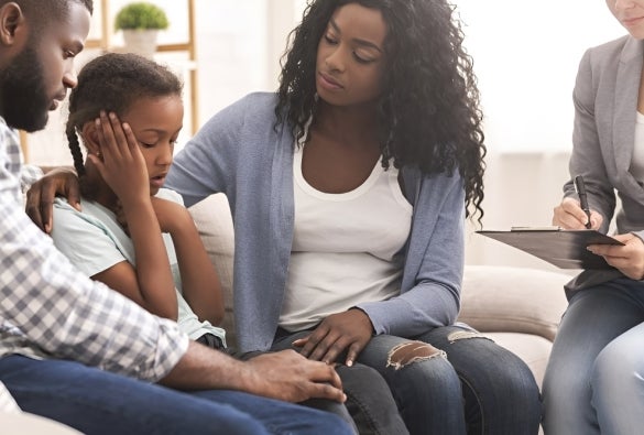 A family of three undergoing therapy with a mental health professional.
