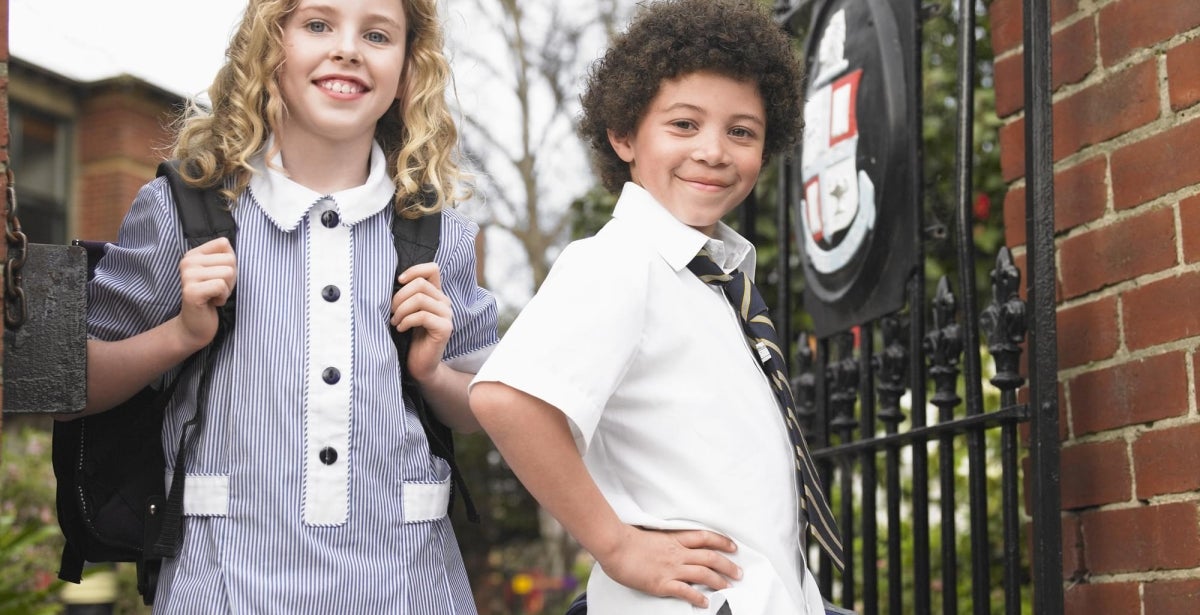 Primary school students posing at the school gate.