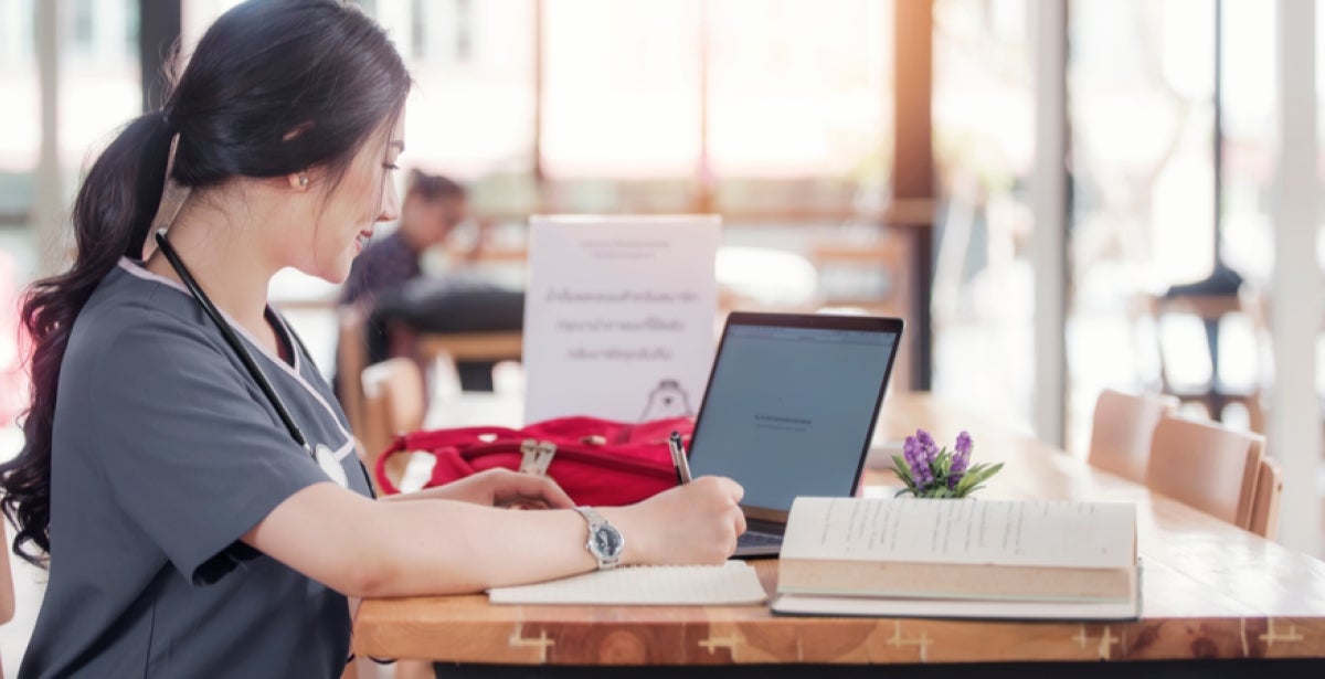 A VU Online Master of Nursing student sits at a desk with her laptop.