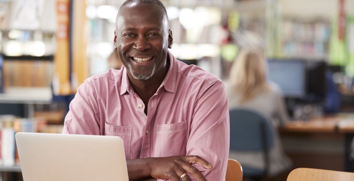 A smiling financial adviser working on their laptop.