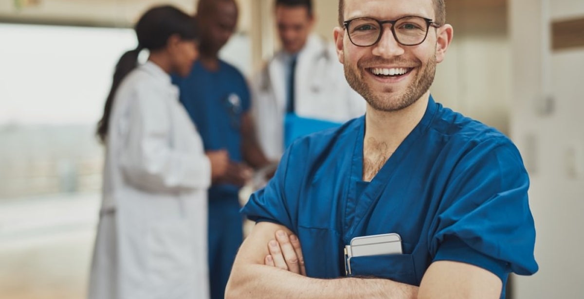 An informatics nurse crossing their arms and smiling.