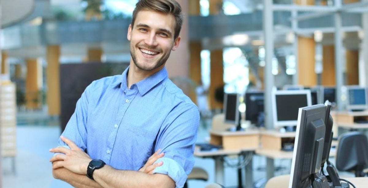 A health promotion professional smiling with arms crossed.