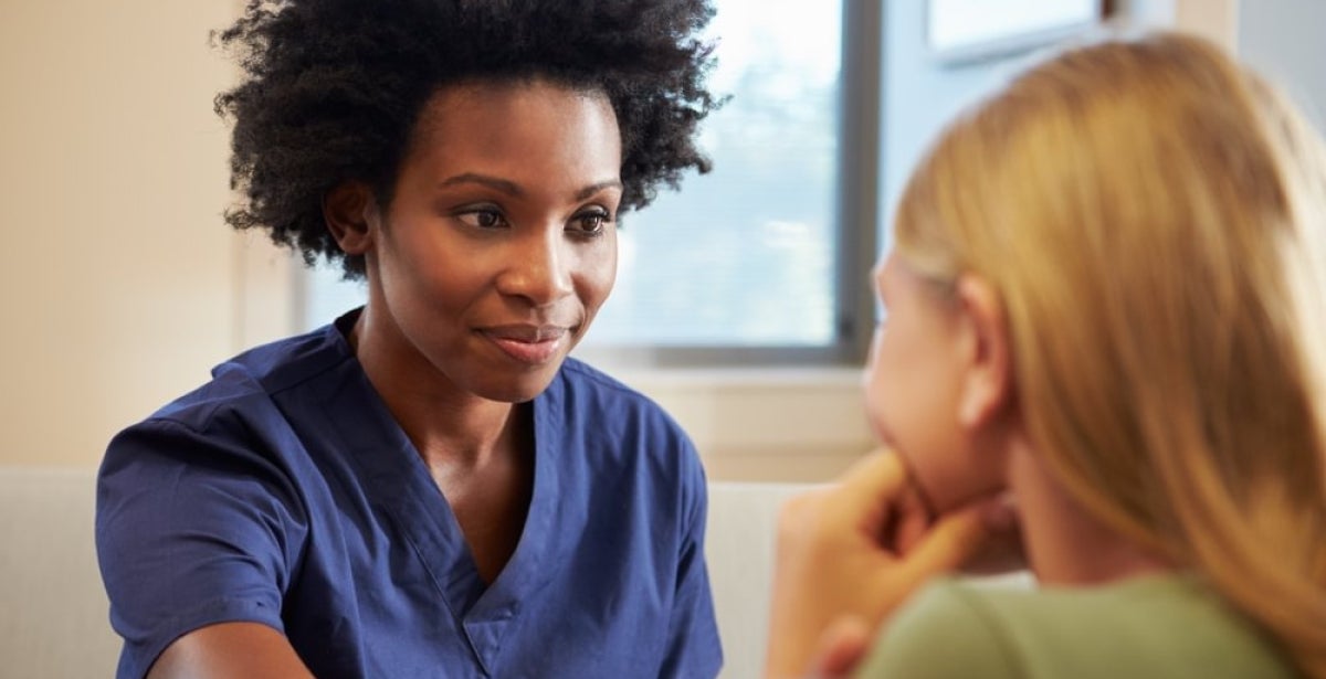 A mental health nurse comforting and helping a patient.
