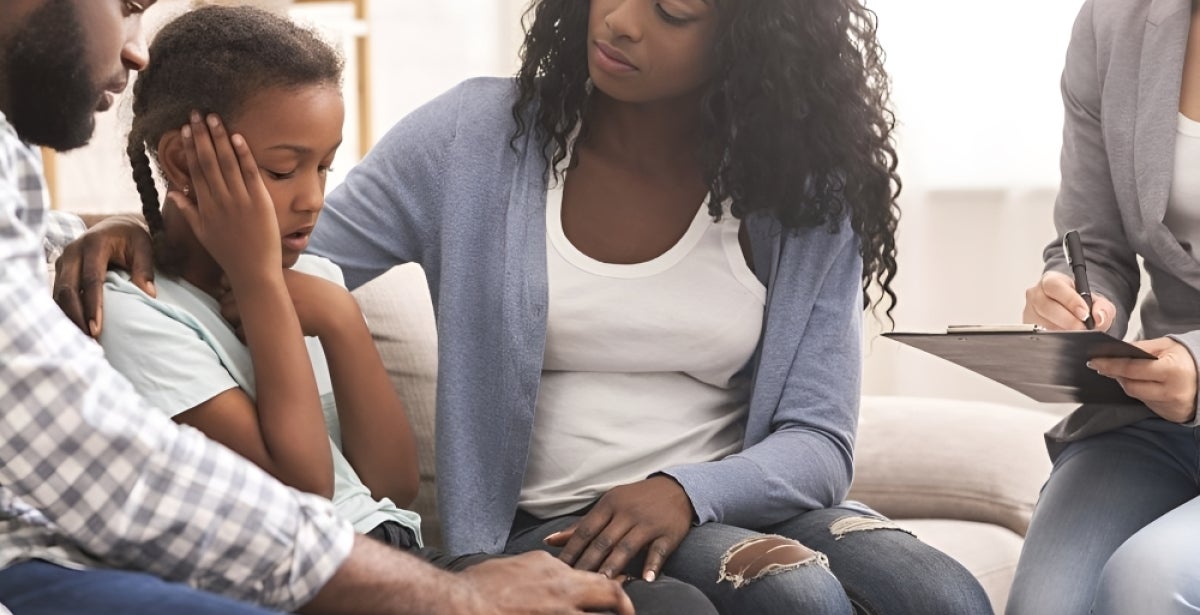 A family of three undergoing therapy with a mental health professional.