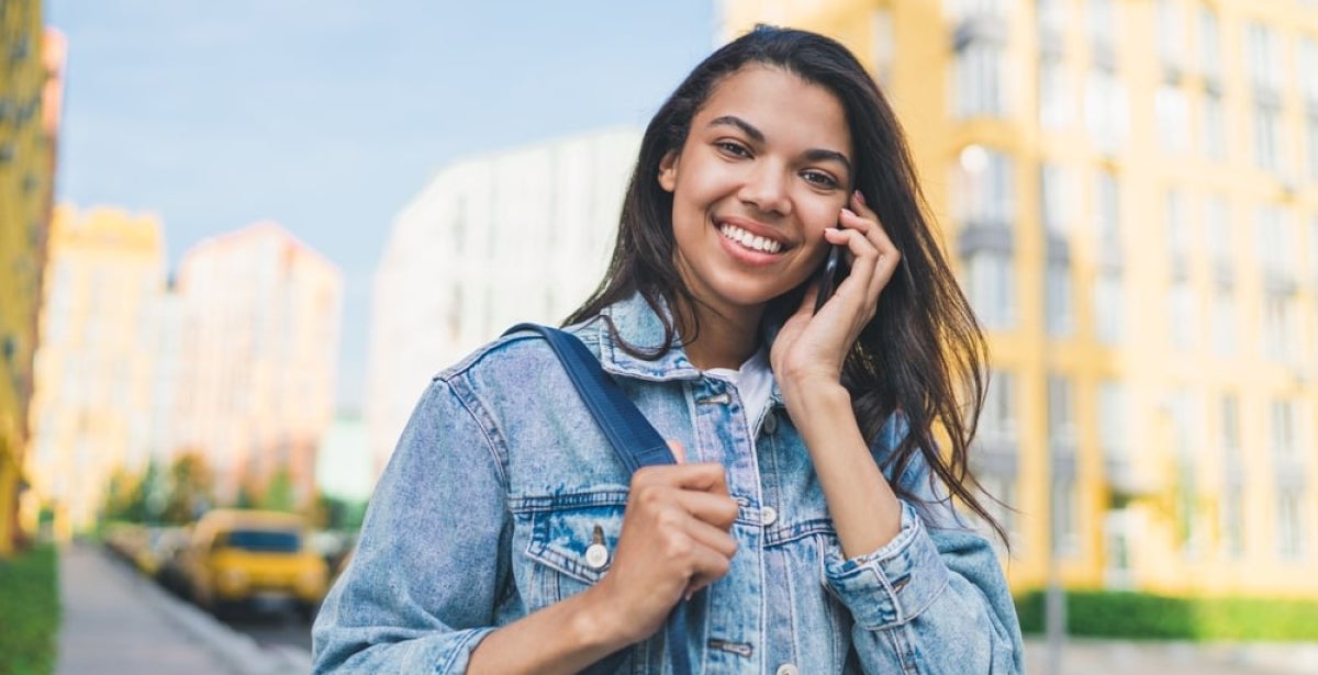 An online MBA student talking on the phone and smiling.