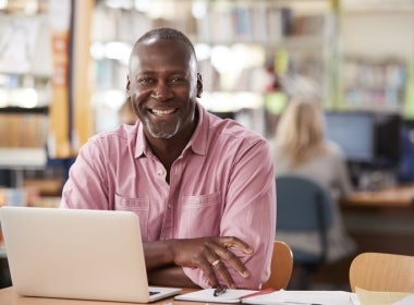 A smiling financial adviser working on their laptop.