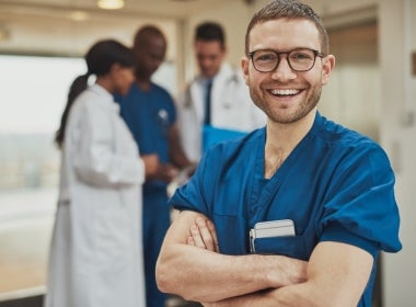 An informatics nurse crossing their arms and smiling.