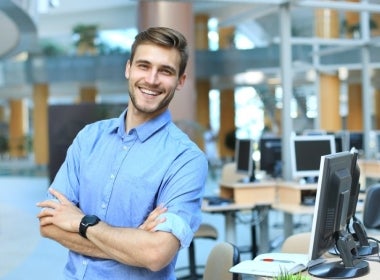 A health promotion professional smiling with arms crossed.