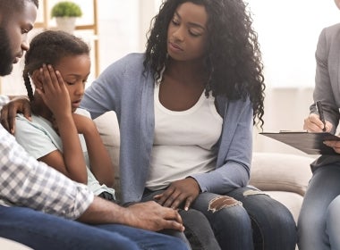 A family of three undergoing therapy with a mental health professional.