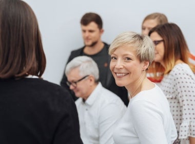 A global health leader smiling during a meeting.