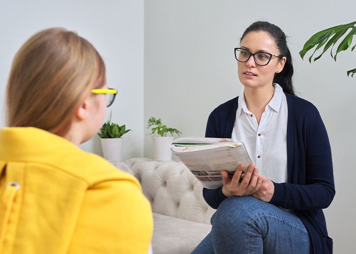 Middle-aged Caucasian female counselor sitting and talking with patient